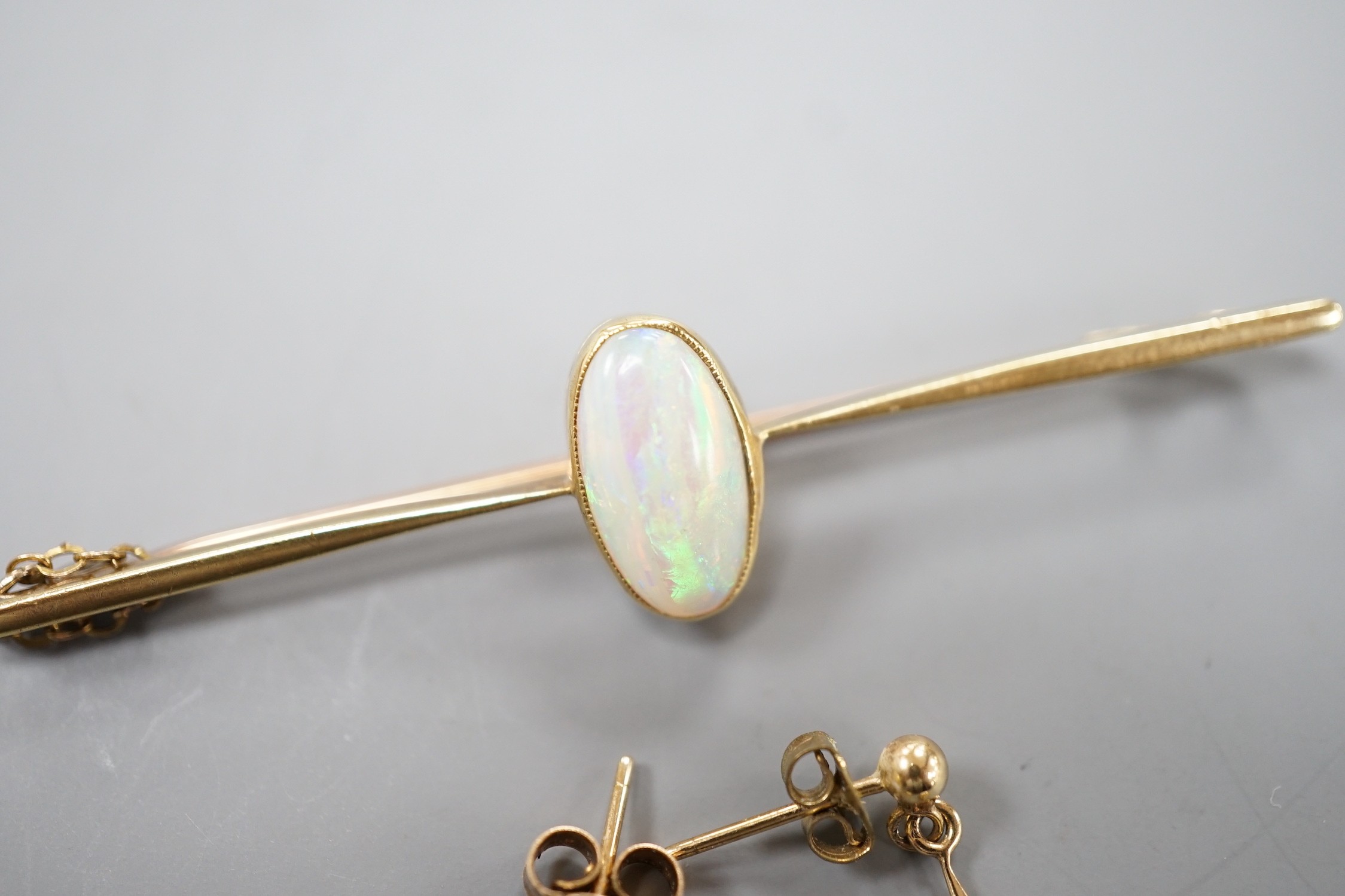 A 15ct and white opal set bar brooch, 60mm and a pair of yellow metal and white opal set drop earrings, gross weight 5.3 grams.